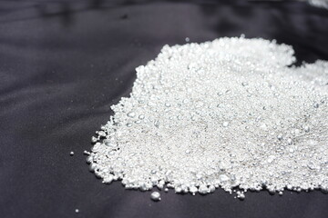 A pile of sparkling pure silver grains, refined to 99.99% perfection, sparkle under the light. Each tiny grain reflects clarity and value.