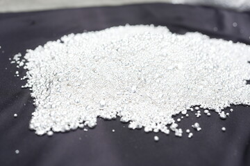 A pile of sparkling pure silver grains, refined to 99.99% perfection, sparkle under the light. Each tiny grain reflects clarity and value.