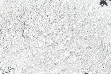 A pile of sparkling pure silver grains, refined to 99.99% perfection, sparkle under the light. Each tiny grain reflects clarity and value.