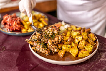 Woman serving grilled chicken with roasted potatoes