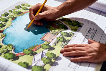 landscape designer reviewing blueprint with pencil, architectural and tree patterns visible, focused on creative planning and detailed design process.Generated by AI