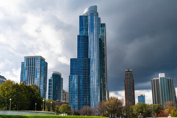Obraz premium Architectural building in business district. Park and skyscraper cityscape. City architecture. Architecture building. City skyscraper. Business skyscraper building. Urban skyline and autumn park