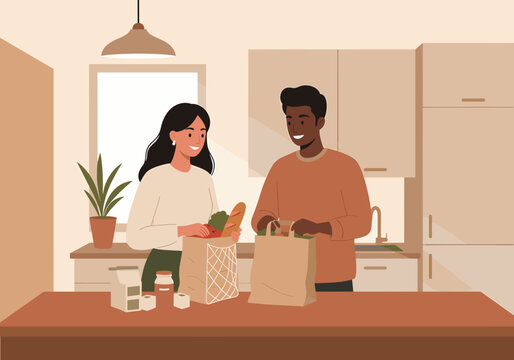 Couple unpacking groceries together in modern kitchen at home  