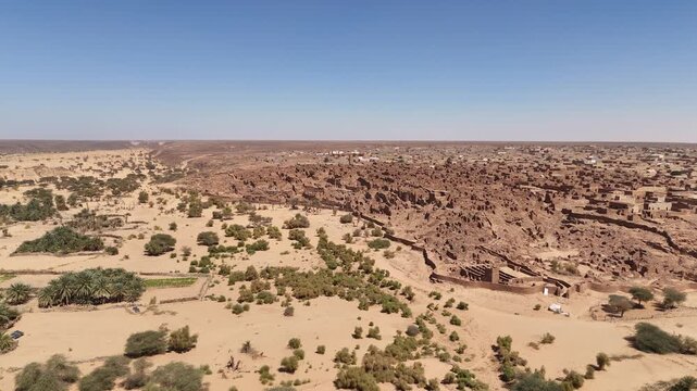 Aerial approach ancient ruins and stone structures in Sahara desert, historic Mauritanian village and World Heritage site