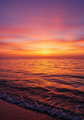 Fototapeta premium Vibrant Sunset Over the Ocean: A breathtaking scene unfolds as the sun dips below the horizon, painting the ocean and sky with a radiant symphony of colors. The calm water reflects the vivid hues.