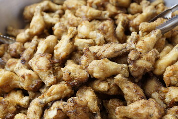 Crispy fried chicken pieces piled together, golden brown snack or fast food meal, crunchy texture and delicious street food background.