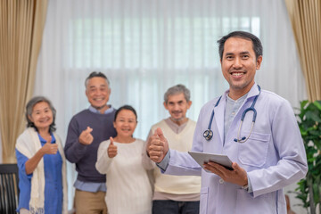 portrait a doctor or psychologist in uniform with stethoscope holding tablet computer,standing in counselling room,background blurred elderly group therapy