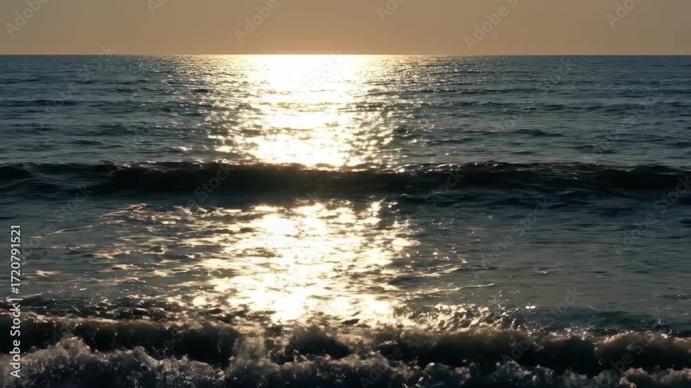 Wall mural dazzling timelapse of golden sunlight dancing and glinting across the surface of gentle ocean waves,