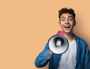 Funny happy brunette man wear dent dental tooth braces brackets advertise use mega phone megaphone loudspeaker bullhorn, isolate beige brown background. Sales ad concept. Free ad text space