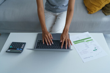concentrated Asian woman using laptop computer creative girl working and typing on keyboard.
