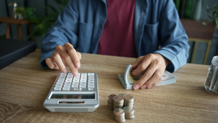 Man calculates finances by calculator Count banknotes and coinsใ