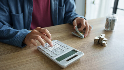 Man calculates finances by calculator Count banknotes and coinsใ