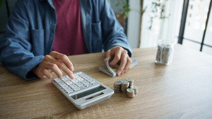 Man calculates finances by calculator Count banknotes and coinsใ