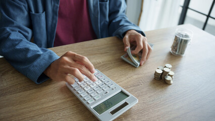 Man calculates finances by calculator Count banknotes and coinsใ
