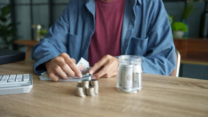 Man planning finances Count banknotes and coinsใ