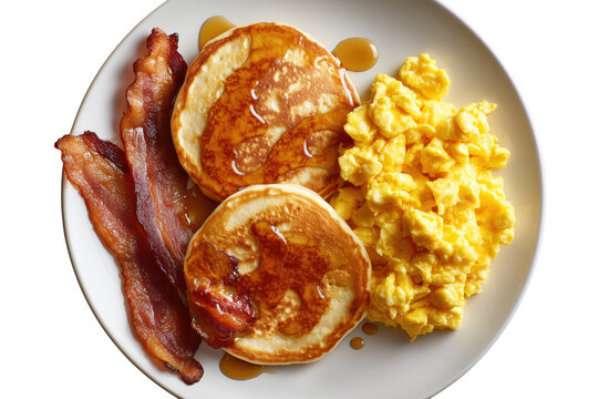 Delicious breakfast plate with pancakes scrambled eggs and crispy bacon served on white plate transparent