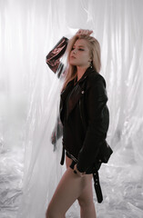 Beautiful woman in black leather jacket on plastic background.
