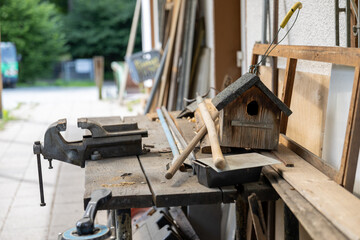 Wooden birdhouse with carpentry tools on rustic workbench in workshop, concept of craftsmanship, woodworking, handmade DIY projects and rural lifestyle