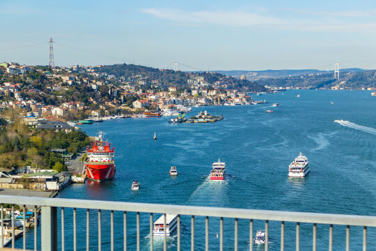 Istanbul, Turkey - March 31, 2025:Beautiful view of the Bosphorus Strait in Istanbul, Turkey, with boats, ferries, and ships sailing under the clear blue sky. The waterfront is lined with houses and