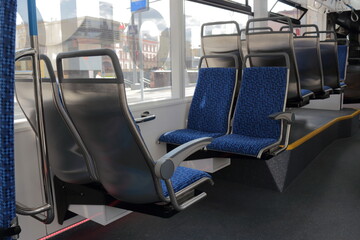 Blue passenger seats on a public tram. An empty tram car with empty seats. Tram seats in an empty car.
