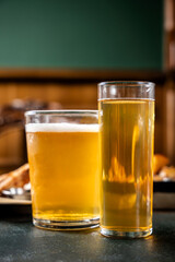 Two glasses of refreshing beer on a pub table.