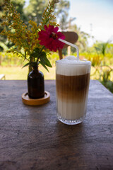 Iced Soy Milk Coffee with Flower Decoration on Wooden Table