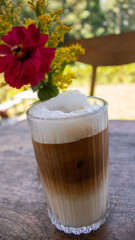 Iced Soy Milk Coffee with Flower Decoration on Wooden Table