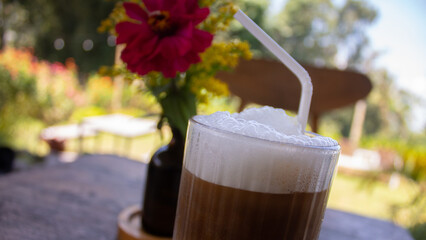 Iced Soy Milk Coffee with Flower Decoration on Wooden Table