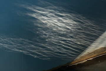 Swiatło odbijające się w wodzie płynącej kanałem z betonu. 