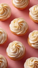 Delicious vanilla frosted cupcakes arranged beautifully on a pink background for a festive dessert display or bakery theme