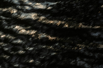 Tekstura wody w złotych promieniach słońca, abstrakcyjne tło natury dla projektu. 