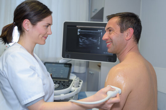 middle-aged man having ultrasound of his upper arm - Powered by Adobe