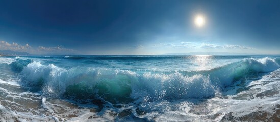 Panoramic view of ocean waves crashing on a sandy beach under a bright sun and clear blue sky
