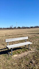 Obraz premium Wooden bench in open field