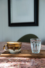 Hot coffee latte with latte art milk foam in cup mug on marble floor desk As breakfast In a coffee shop at the cafe, during business work concept