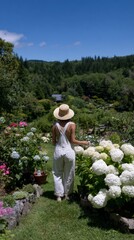 Young caucasian female enjoying a walk in a lush flower garden on a sunny day