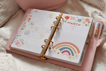 a pink planner book with a calendar on it