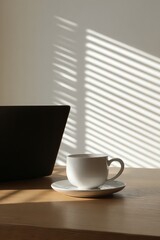 White Coffee Cup on Wooden Desk with Laptop and Sunlight Stripes