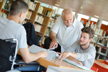 young cheerful students and teacher in library