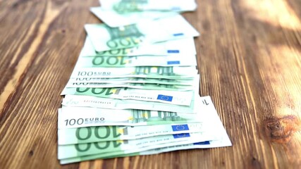 A lot of bills in a hundred euros spread out on the desk. Counting 100 Euro banknotes. Male hands counting European 100 hundred Euro money banknotes. euro money bills, european economy value. - Powered by Adobe