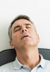 Obraz premium Middle-aged man relaxing with eyes closed in a calm setting 