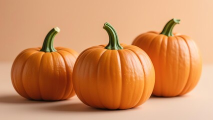 Obraz premium Three realistic pumpkins with green stems, one on a wooden block, against a light orange gradient background with soft shadows and warm tones