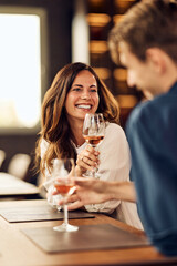 Smiling Woman Enjoying a Drink with a Friend at a Cozy Setting