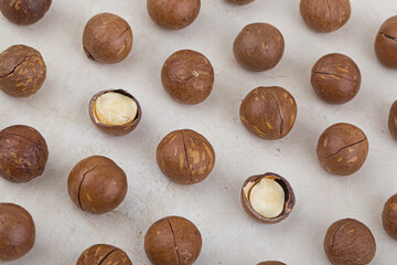 Shelled and unshelled macadamia nuts on white background