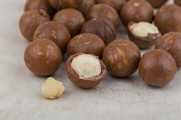Shelled and unshelled macadamia nuts on white background