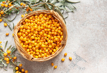 Fresh sea buckthorn berries overflowing a small wicker basket