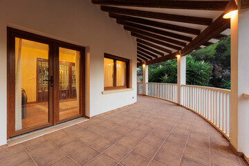 Evening view of the Mediterranean-style terrace with illuminated windows and garden features.
