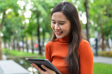 woman is smiling while holding  tablet