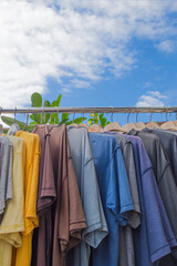 Clothes hanging on a clothesline against blue sky with white clouds