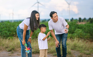 family of three,  man and two children, are standing in  field